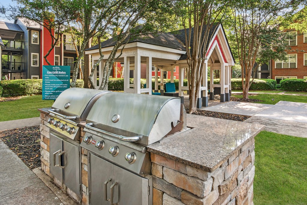 A large outdoor grill is situated on a stone platform in a grassy area at Elme Druid Hills, Atlanta, Georgia